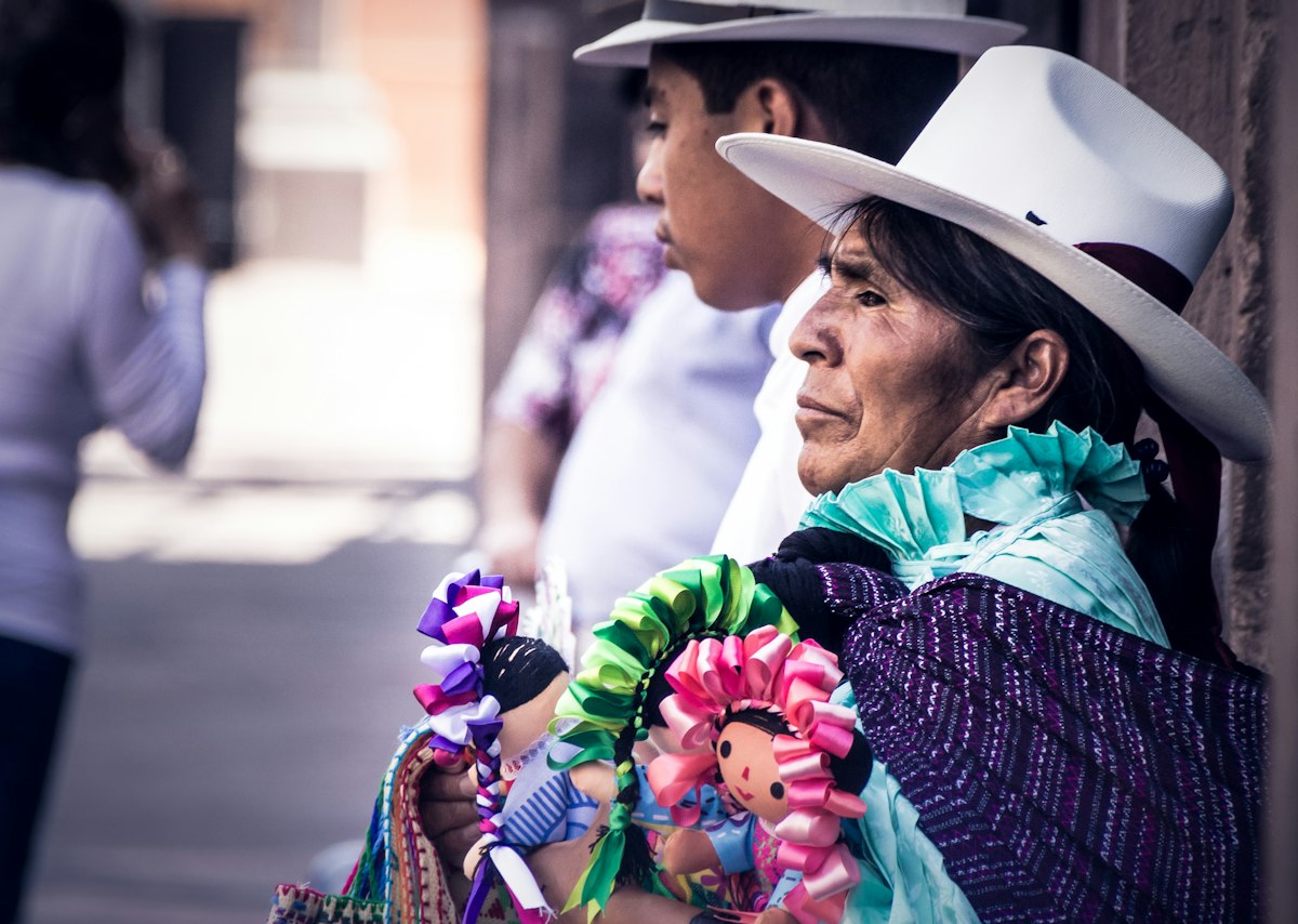 Femme au chapeau blanc, foulard coloré, dans une rue mexicaine
